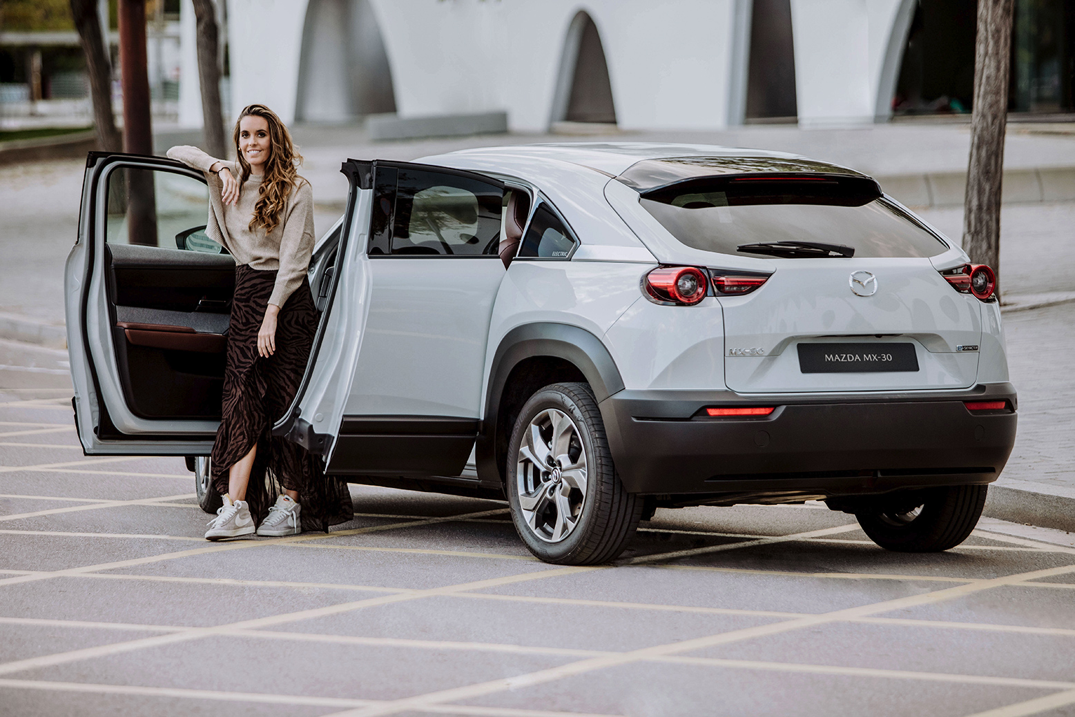 Ona Carbonell posando con el nuevo Mazda MX-30 con sus puertas abiertas