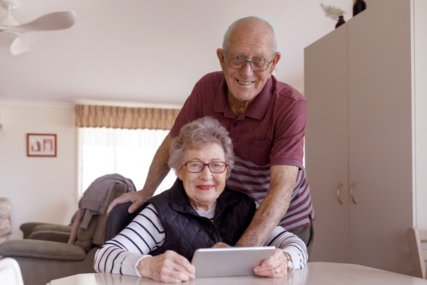 Pareja de ancianos son felices usando una tablet sin saber si la miran o no