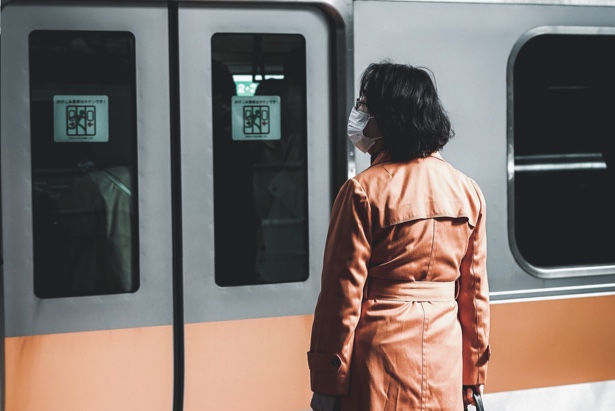 En la foto: una mujer con mascarilla a la espera del tren para ir a trabajar