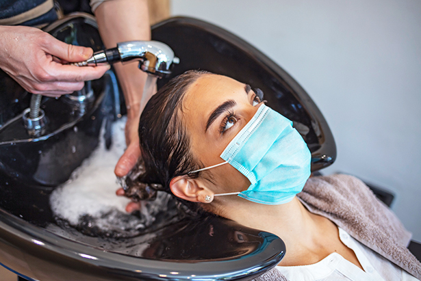 Mujer lavándose el pelo en una peluquería