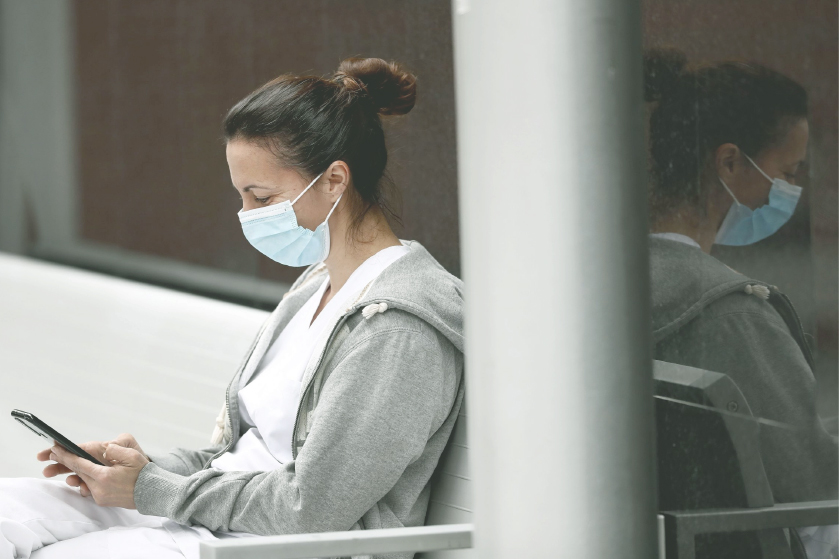 Una enfermera mira su móvil en su pausa