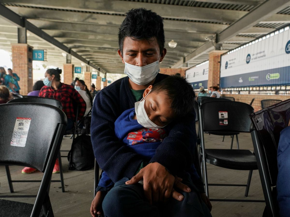 Foto: Un hombre con su hijo en brazos. (Reuters)