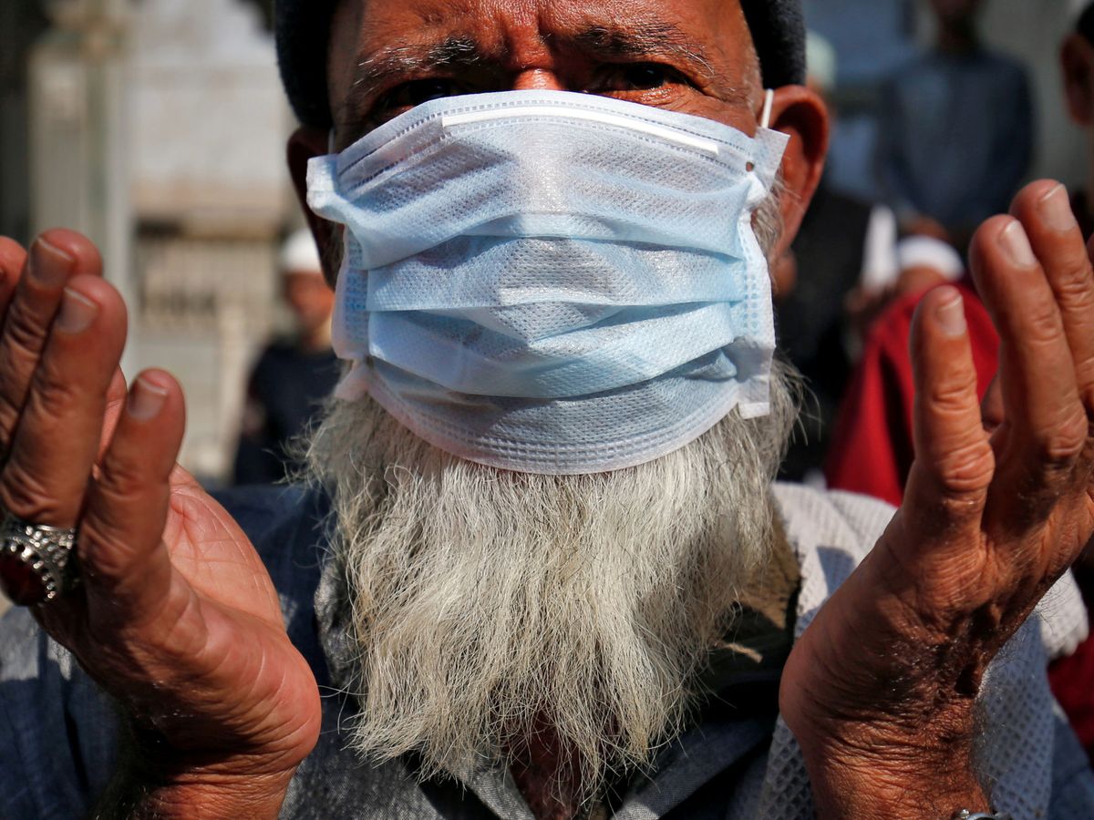 Foto: Un musulmán con mascarilla reza por las víctimas del coronavirus en una mezquita en Ahmedabad, India. (Reuters)