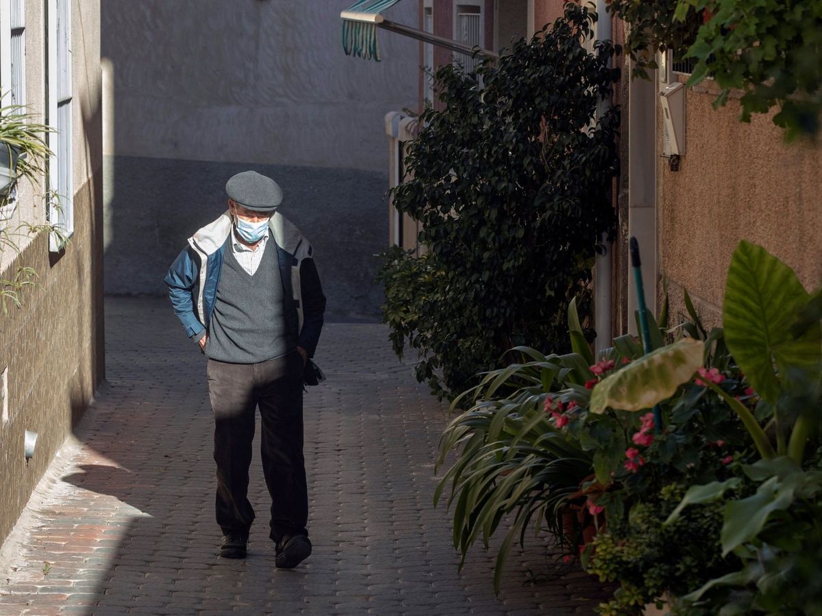 Foto: Un hombre con mascarilla camina por una calle de Albudeite, Murcia