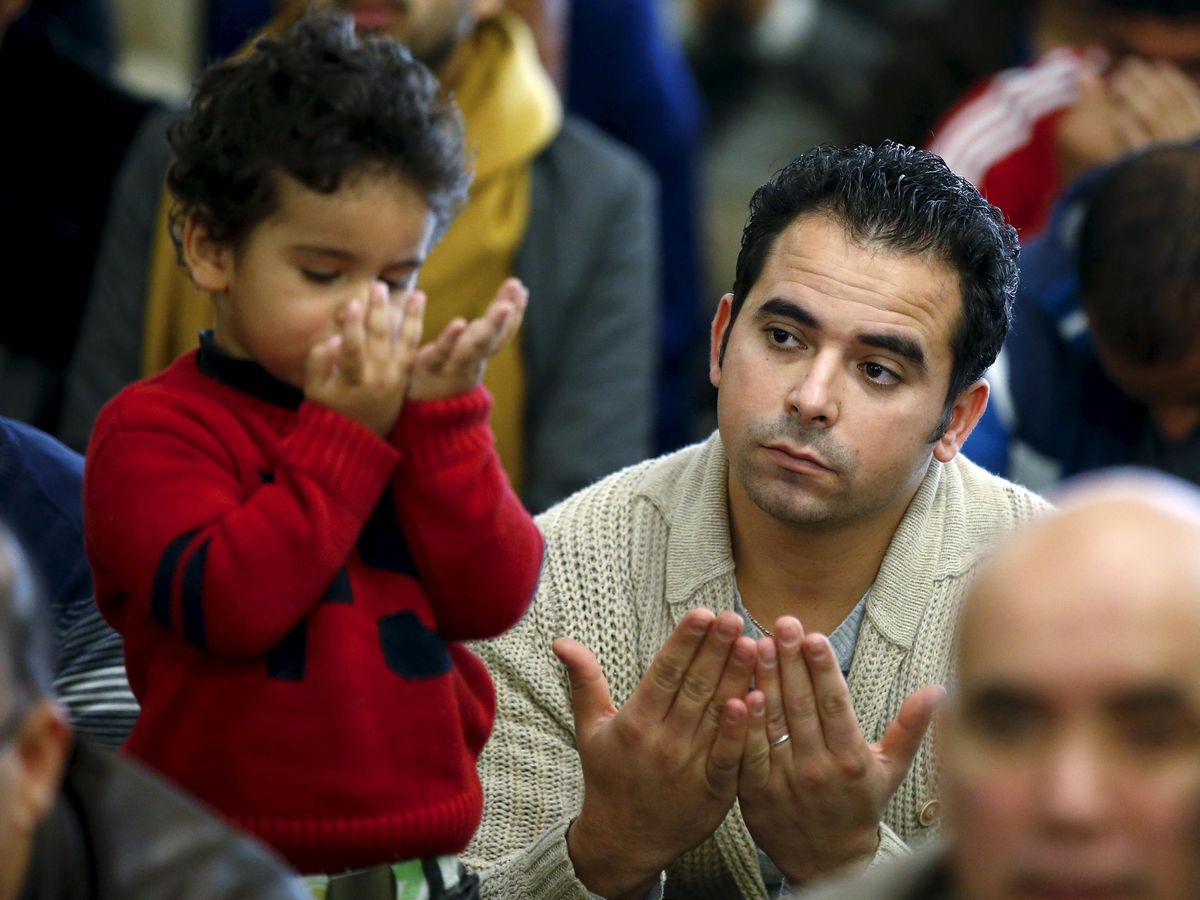 Foto: Un niño imita a su padre durante una celebración religiosa en la mezquita de la M-30 en Madrid. (Reuters)