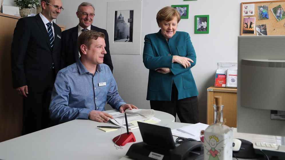Foto: La canciller alemana, Angela Merkel (d), habla con los trabajadores de una oficina de empleo. (EFE)