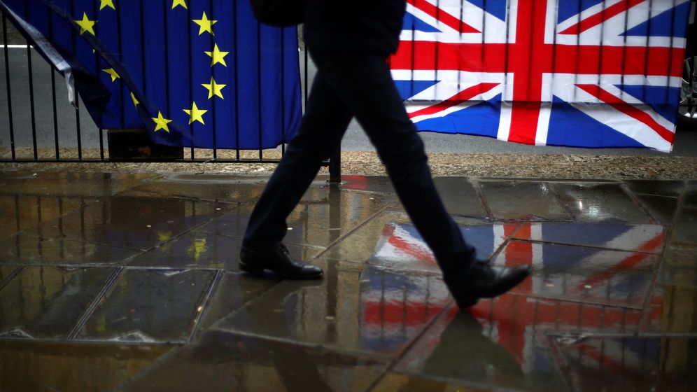 Foto: Una persona camina ante las banderas europeas y británicas en Londres. (Reuters)