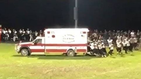 Jugadores de fútbol americano sacan a empujones una ambulancia que había quedado atascada en el campo