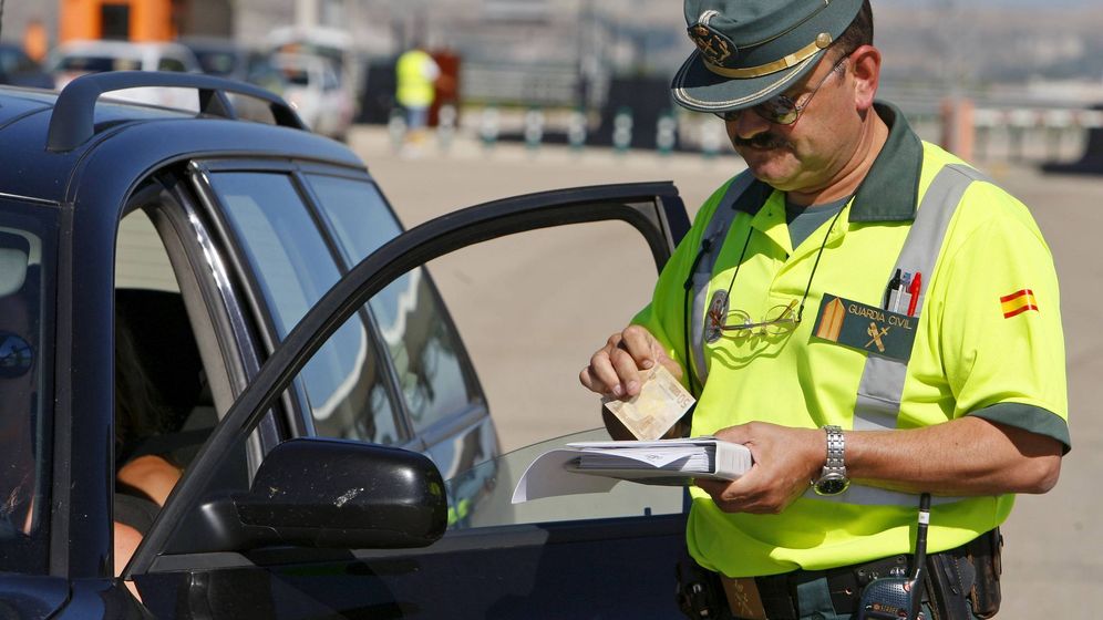 Foto: Un guardia civil, poniendo una multa por velocidad. (EFE)