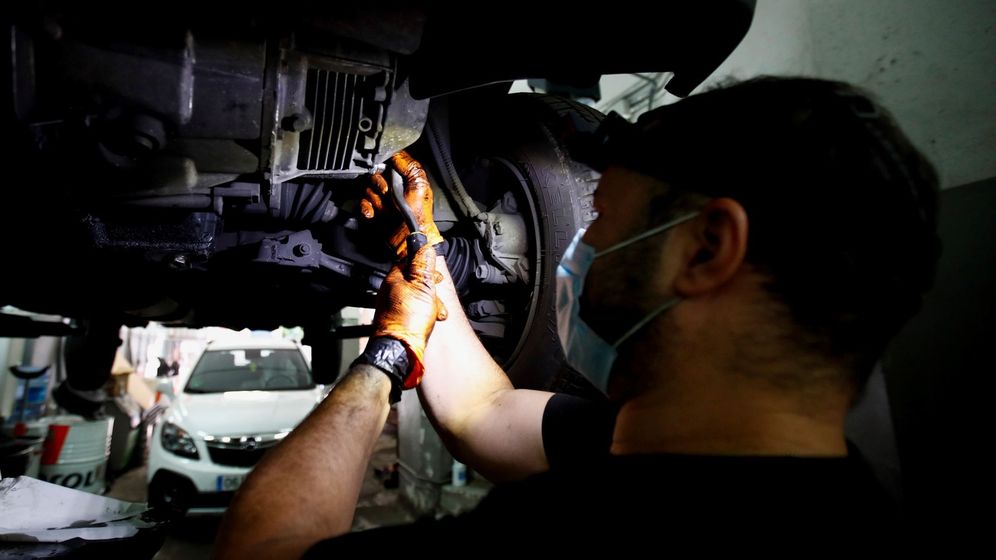 Foto: Un mecánico trabaja, con mascarilla, en un taller en Madrid. (EFE) 