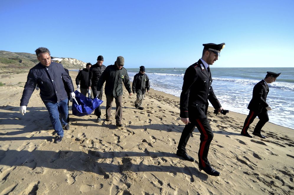 Foto: Agentes transportan el cadáver de un inmigrante en la playa de Siculiana, Sicilia. (Reuters) 
