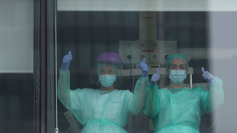 Foto: Dos enfermeras saludan desde las ventanas de La Paz, en Madrid. (Reuters)
