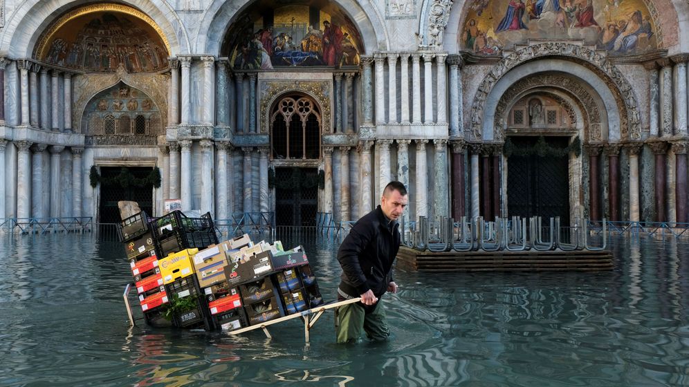 Foto: Un hombre cargando con fruta y verdura en las pasadas inundaciones en Venecia el pasado diciembre. (Reuters)