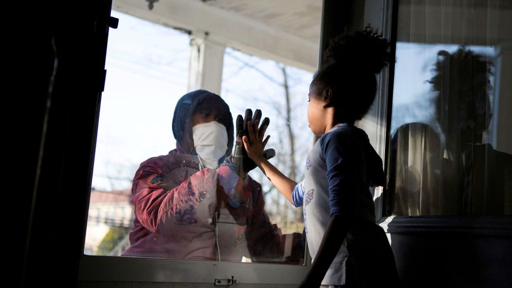 Foto: Una médico saludando a su hija en su casa de Nueva York. (Reuters)