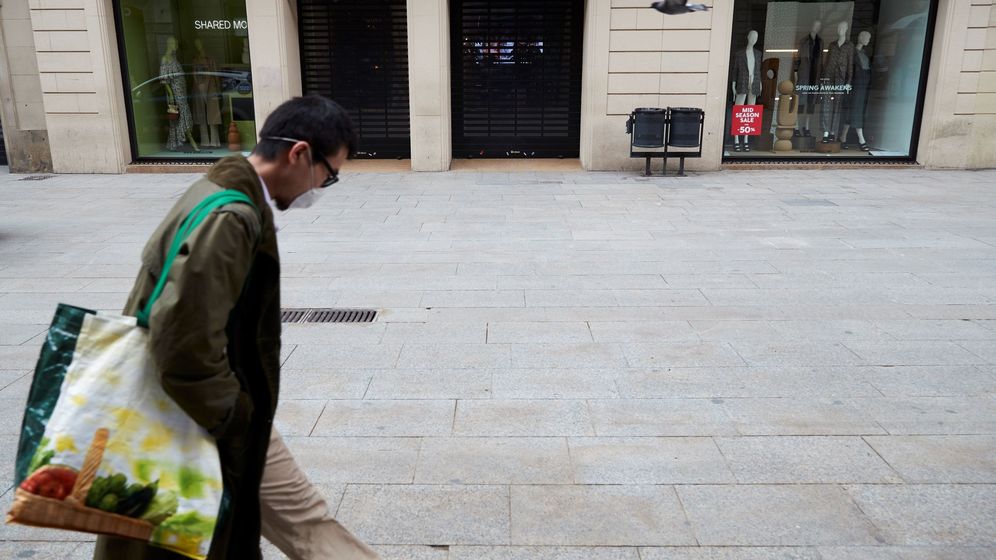 Foto: Un hombre regresa a su vivienda desde el supermercado, ayer, en Barcelona. (EFE)