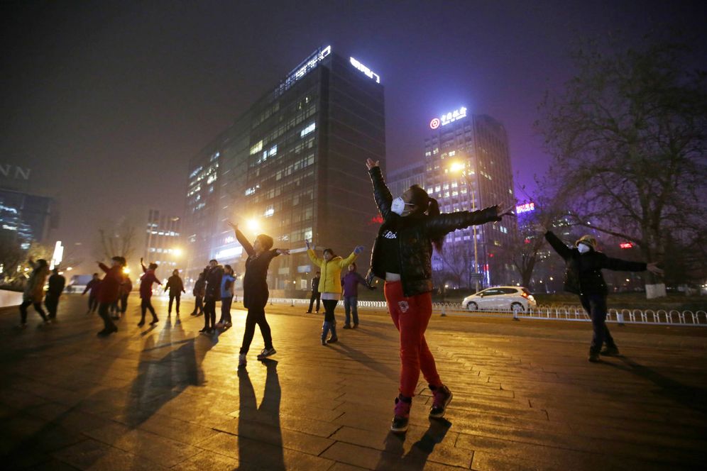 Foto: Mujeres con mascarillas para protegerse de la contaminación hacen ejercicio en Pekín, China. (Reuters)