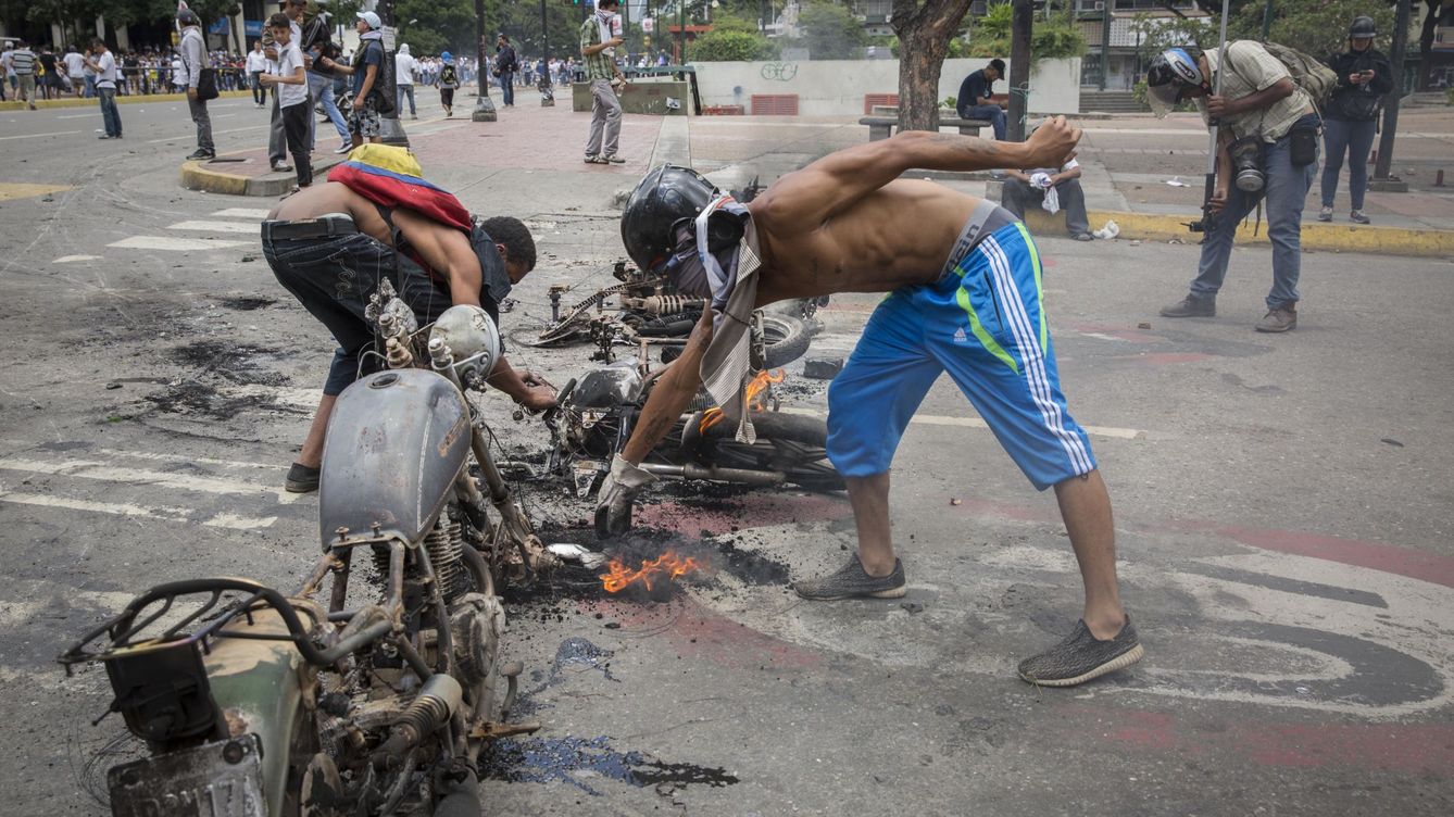 Foto: Manifestantes opositores reconstruyen unas barricadas con motocicletas quemadas en Caracas, ayer, 30 de julio de 2017. (Reuters)