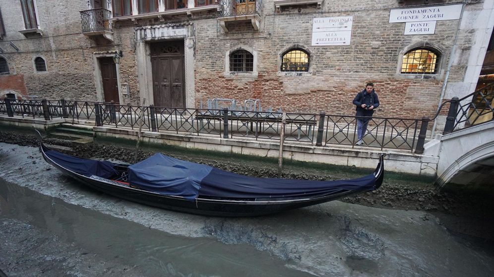 Foto: Una góndola permanece amarrada en un canal prácticamente sin agua en Venecia. (Efe)